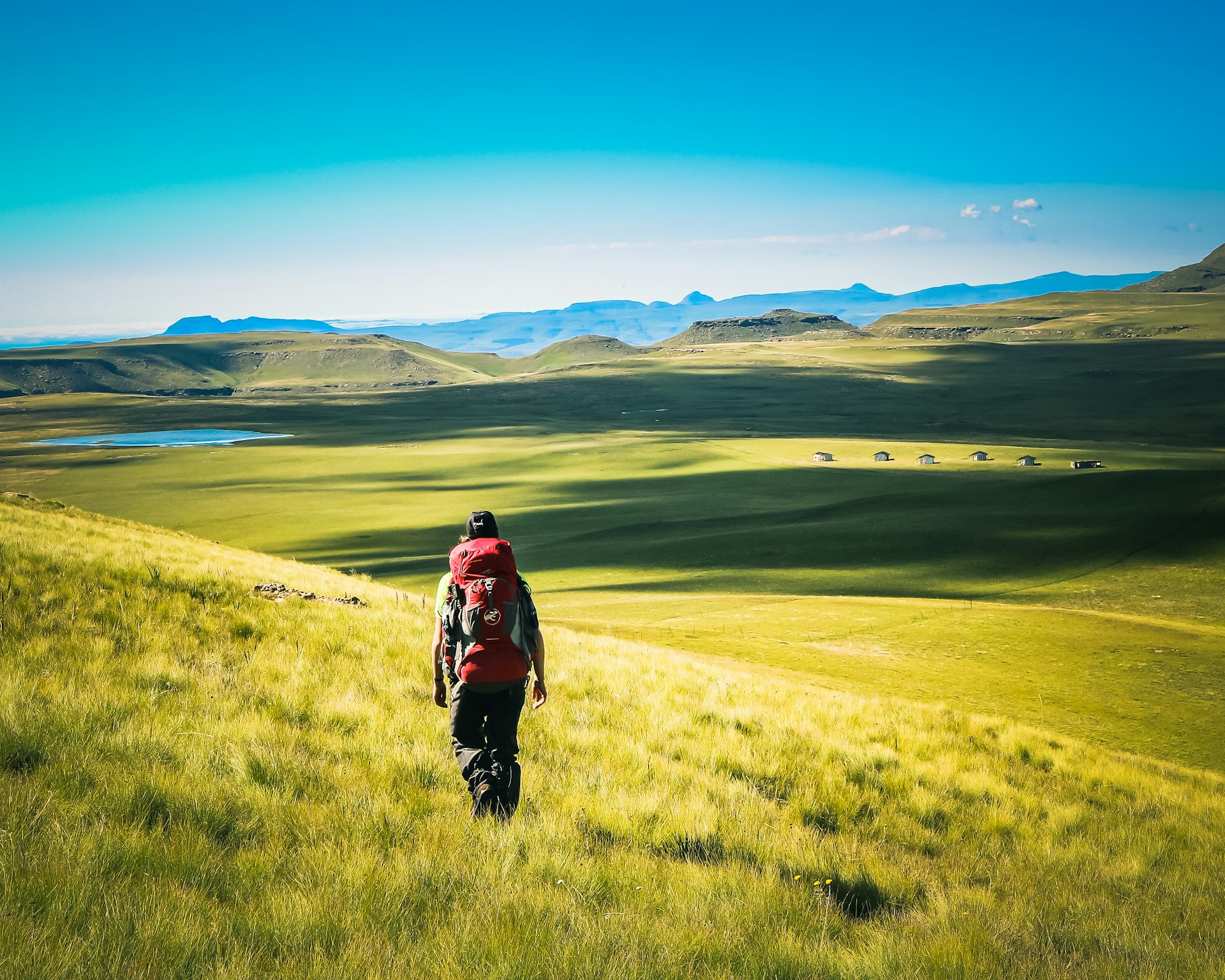 A man walking through a green Lesotho highland valley